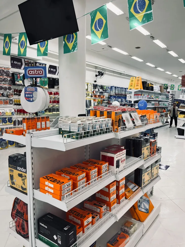 Visão interna da Jhow Mais com prateleiras, materiais e acessórios para obra